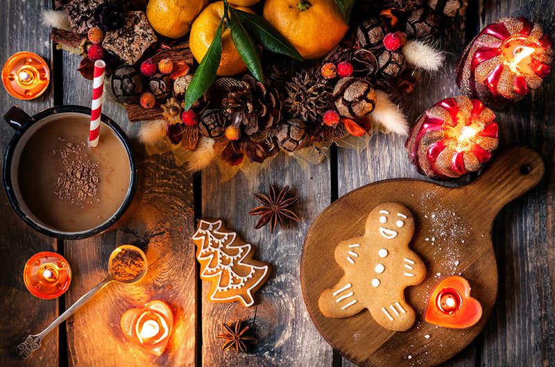 Holiday wreath, gingerbread cookies and hot chocolate laid out on a table