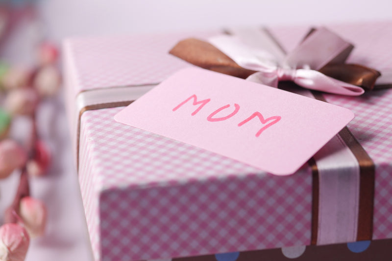 Pink wrapped gift with tag that says mom.